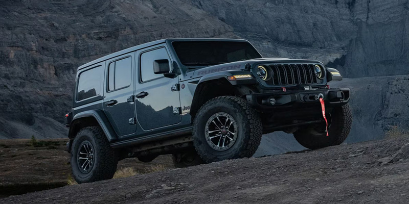 2026 Jeep Wrangler on rocky terrain showing off-road capability.