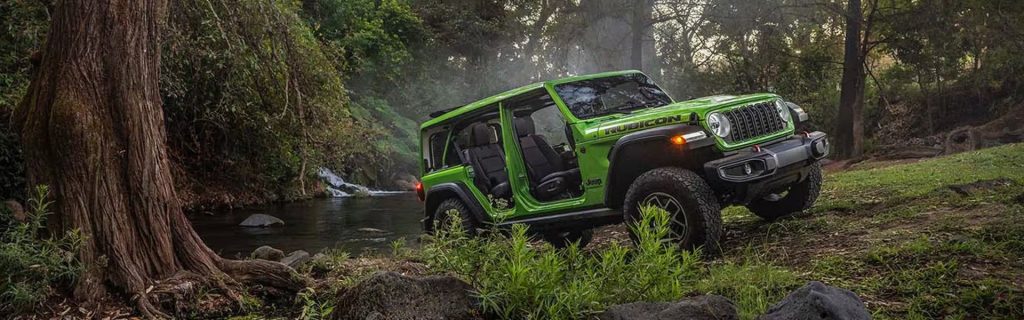 A 2026 Jeep Wrangler Rubicon in green, off-roading.