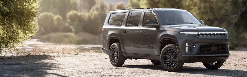 Gray Jeep Wagoneer S parked outdoors near a scenic riverside, showcasing its modern design and refined SUV styling.