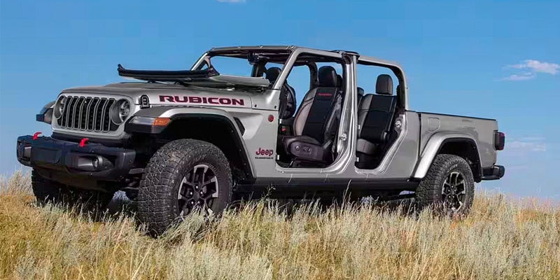 silver 2024 jeep gladiator parked in a filed with tall grass